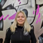Etsivä nuorisotyöntekijä Miia Hämäläinen, taustalla värikäs seinä