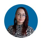 Sinisellä taustalla tummahiuksinen nainen, jolla on pyöreät silmälasit ja mustavalkokuvioinen paita.