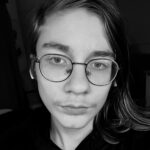 Mustavalkoinen kuva mies oletetusta, jolla silmä lasit ja puolipitkät ruskeat hiukset.