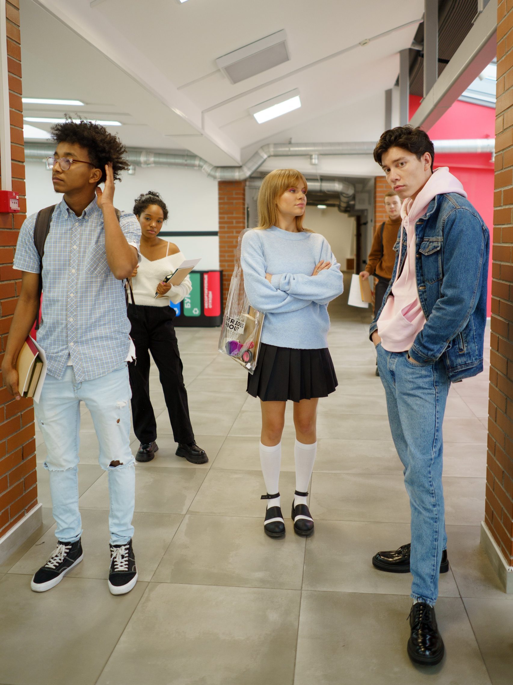 Joukko nuoria seisoo koulun käytävällä. Avainsanoja: koulu, opiskelu, kaveruus