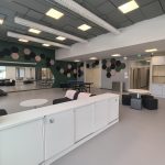 Jynkän nuorisotilan olohuone. Olohuoneessa on valkoiset matalat kaapit ja pingispöytä. Lattia on harmaa ja takaseinä on vihreä.