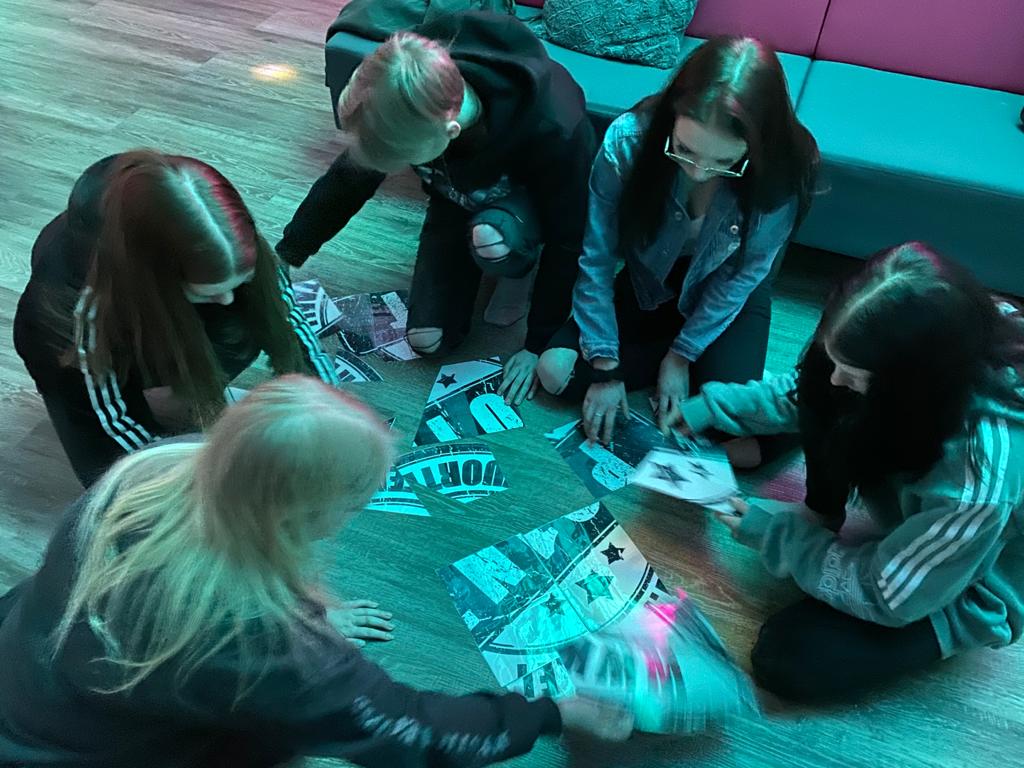 Pieni ryhmä nuoria ratkaisemassa po1nt logo palapeliä.