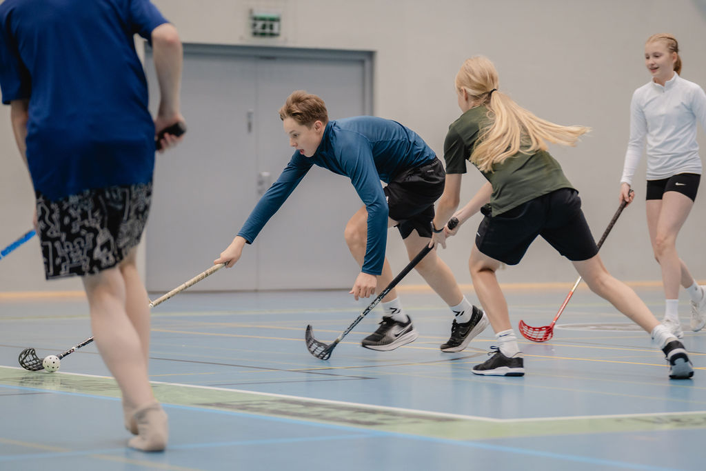 Neljä nuortaa pelaa sählyä