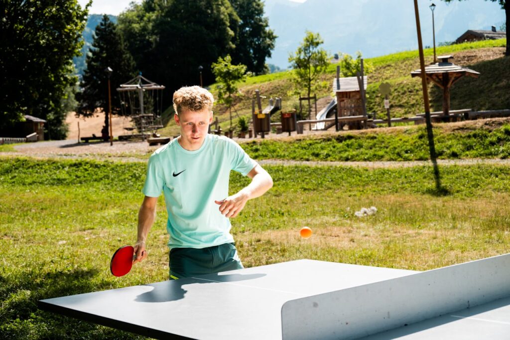 Nuori poikaoletettu pelaa pingistä ulkona