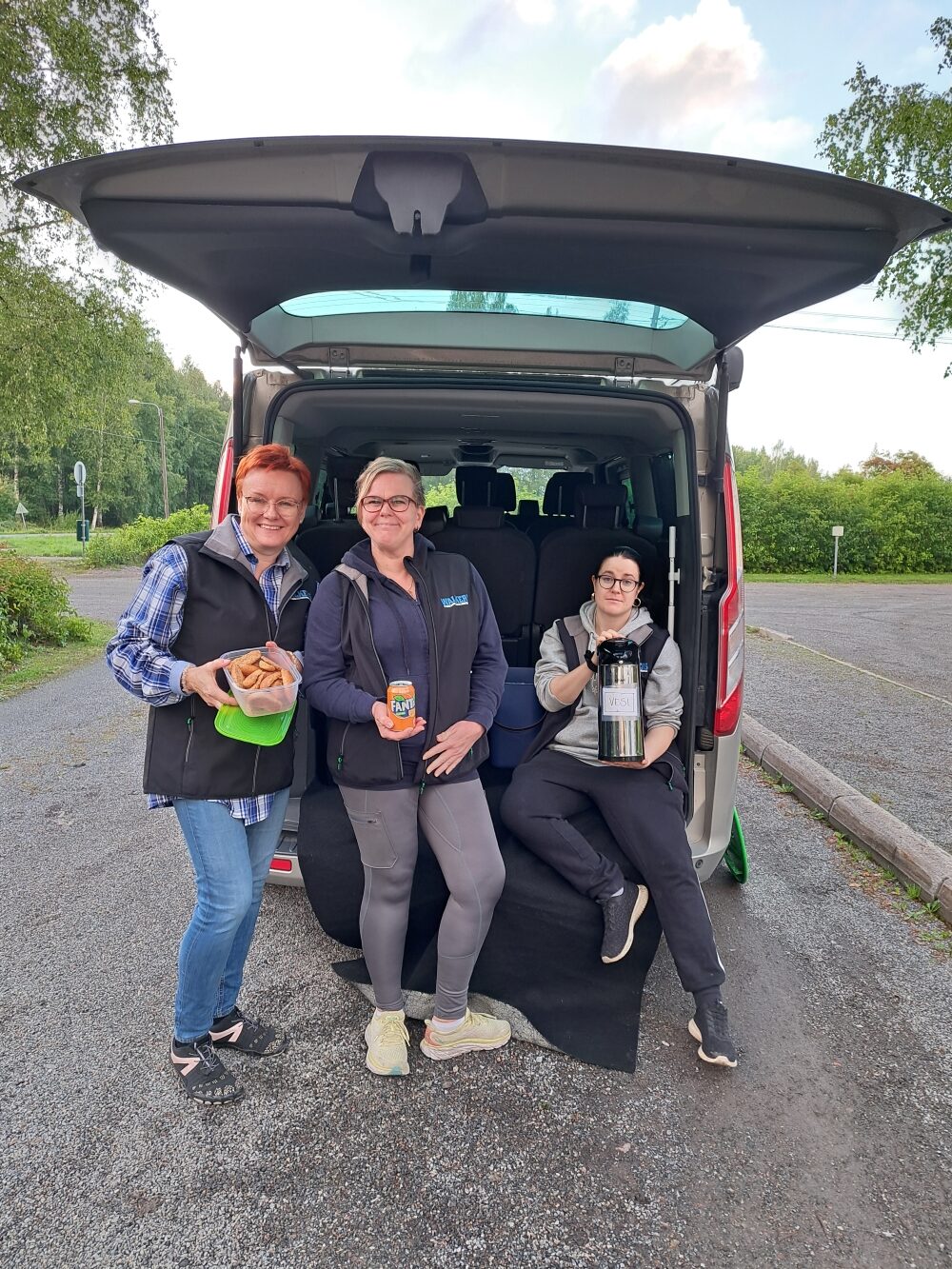 Pilvisenä päivänä Walkers -auton takana oleskelee kolme hymyilevää työntekijää, joista yksi pitelee kahvitermosta, toinen Fanta -tölkkiä ja kolmas eväsrasiaa, joka on täynnä kanelikorppuja.
