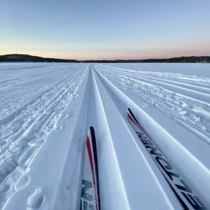 Talvinen maisema jäältä, jossa hiihtolatu ja suksen kärjet.