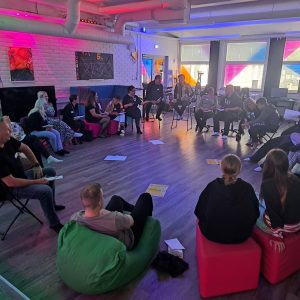 nuoria ja aikuisia istuu ympyrässä ja keskustelevat keskenään